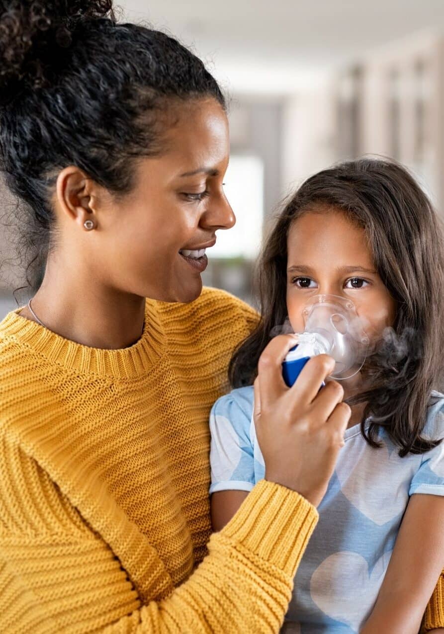 mother helping daughter with asthma inhaler square